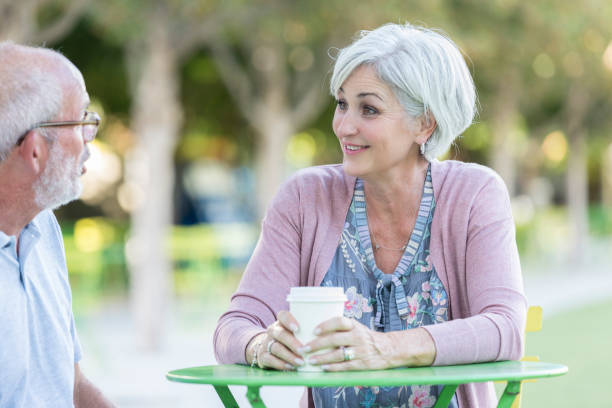 istock Senior woman enjoys sidewalk cafe coffee with husband 1053521730