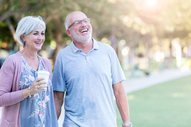 istock Senior couple enjoy stroll through public park 1053521732