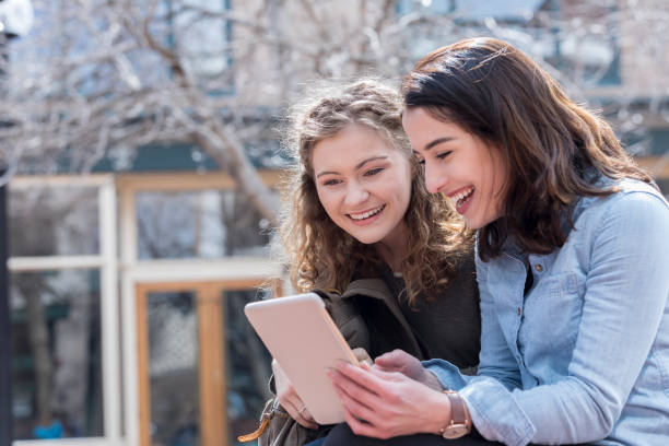 istock Cheerful friend watch something on digital tablet 1053524184