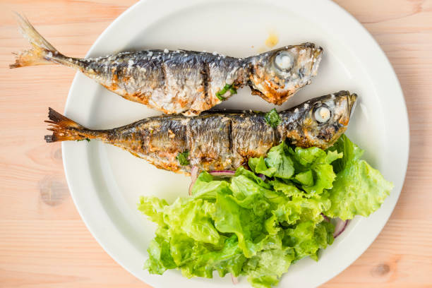 istock Two freshly barbecued mackerels served with lettuce salad 1053525532