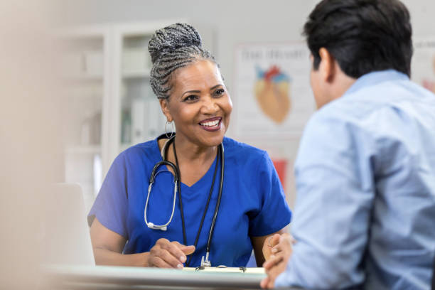 istock Cheerful African American nurse talks with patient 1053525914