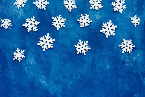 istock white snowflakes homemade on blue background, winter, place for text 1053526024