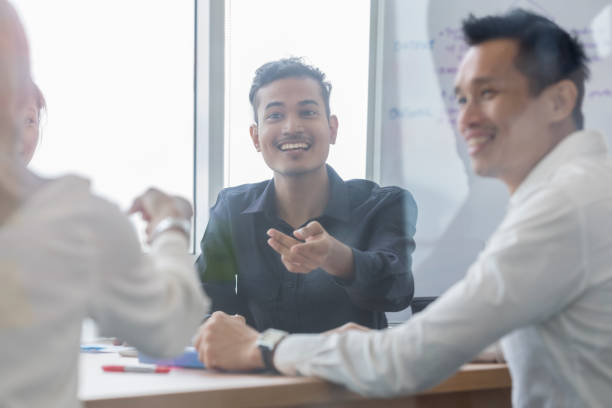 istock Cheerful businessman enjoys staff meeting 1053526356