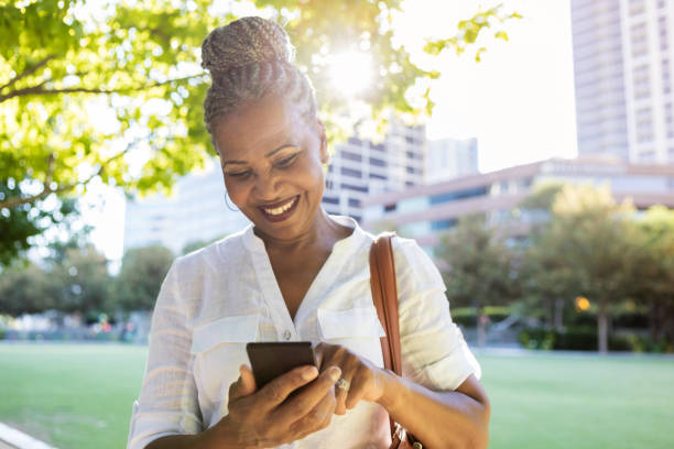istock Woman video chats while walking in city park 1053526510
