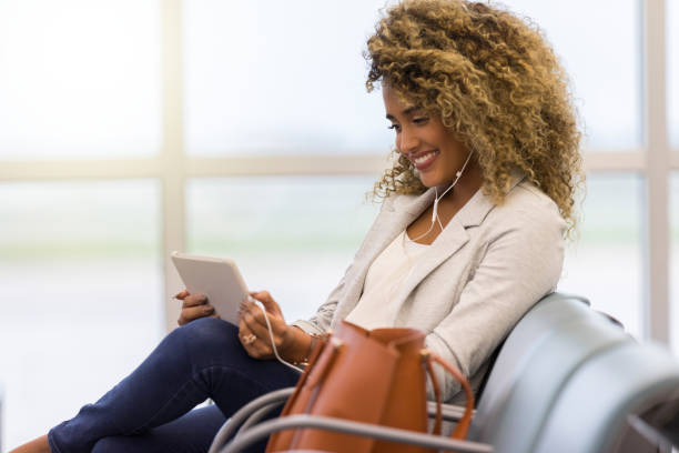 istock Young businesswoman enjoys music while waiting for flight 1053526970