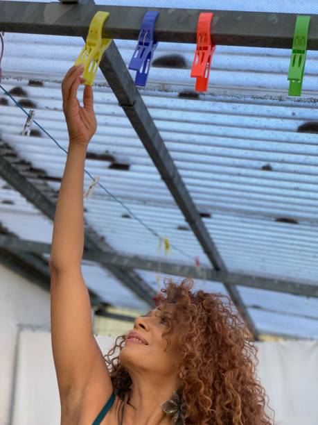 Beautiful woman reaching up for clamps