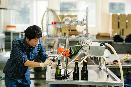 Brew mater bottling his product in a small batch craft beer brewery in Japan