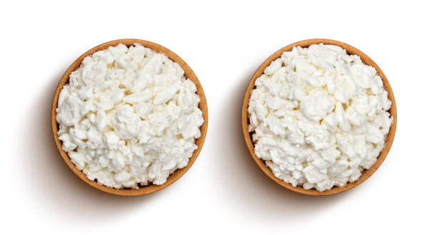 Cottage cheese in wooden bowl isolated on white background, top view Cottage cheese in wooden bowl isolated on white background with clipping path. Top view cottage cheese photos stock pictures, royalty-free photos & images