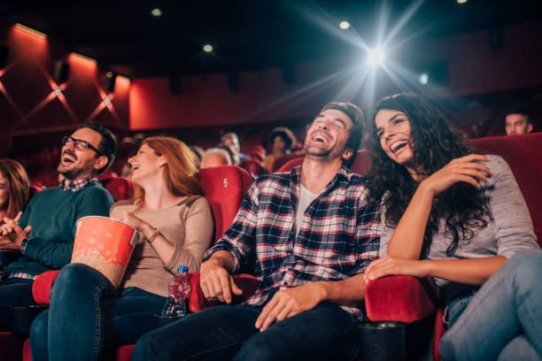 Laughing young people at cinema Happy four friends at cinema together film premiere stock pictures, royalty-free photos & images