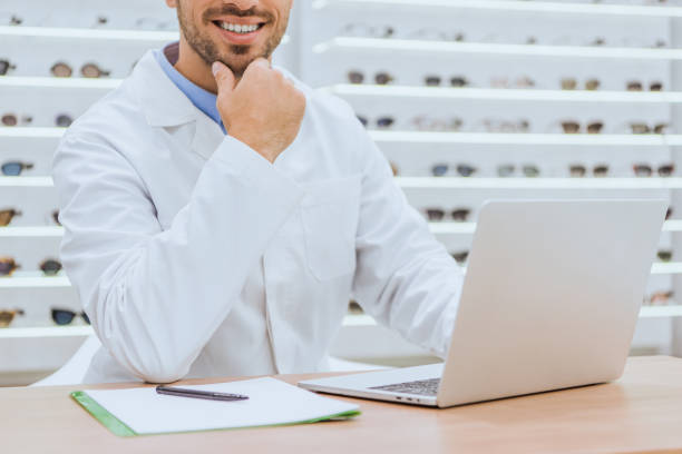 istock cropped view of optician using laptop at table with papers in optica 1053540512