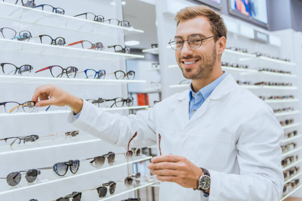 istock smiling optician in white coat taking eyesight from shelves in ophthalmology 1053540534