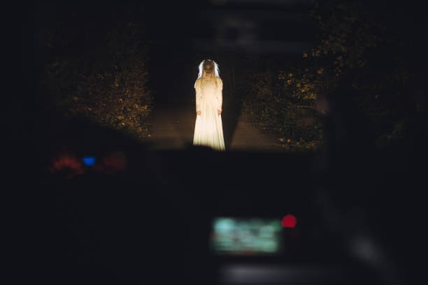 istock Scary witch  in front of a car 1053541330