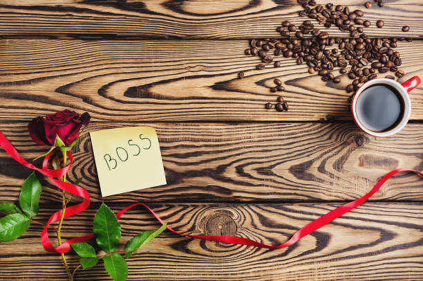 jefe de inscripción en papel al lado de rosa roja con cinta y taza de café junto a granos de café en la mesa de madera vieja. vista superior con espacio de copia. concepto de día de san valentín - coffee bean coffee flower ribbon fotografías e imágenes de stock