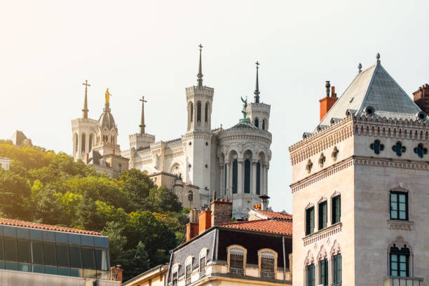 Basilica Notre Dame de Fourviere in Lyon city buildings architecture wonderful monument in France seen from Saone river point of view Color photography of Lyon city buildings, french culture architecture and wonderful ancient monuments in France, in Rhone, Auvergne-Rhone-Alpes region, seen from a boat on Saone river point of view in summer. Image taken from public area outdoors, along riverbank. fourviere stock pictures, royalty-free photos & images