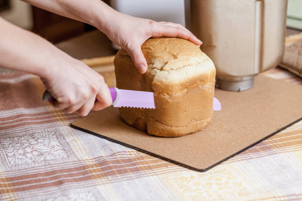 istock Hostess cuts loaf of bread with big knife 1053551160