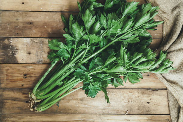 istock Two bunches of celery lie on boards 1053551302