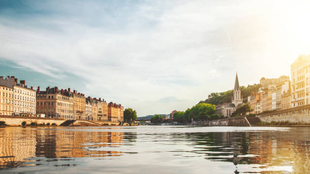 Beautiful sunset over Lyon city buildings with St Georges church on right in France seen from Saone river point of view stock photo