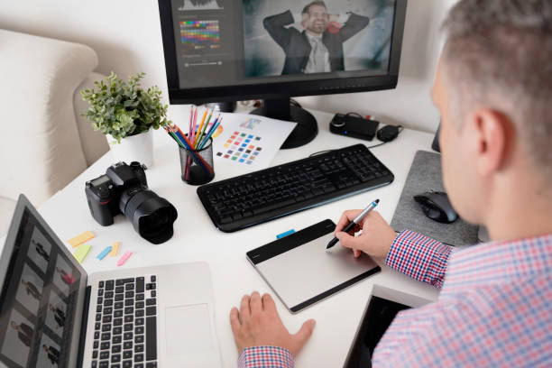 istock Graphic designer uses a pen and graphic tablet 1053553150