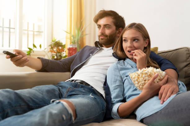 istock Couple watching TV on a sofa at home 1053553268