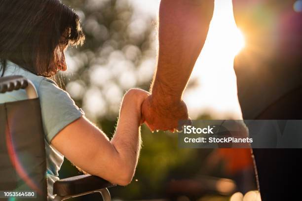 Paar Hände Während Des Sonnenuntergangs Stockfoto und mehr Bilder von Andersfähigkeiten - Andersfähigkeiten, Rollstuhl, Mithilfe