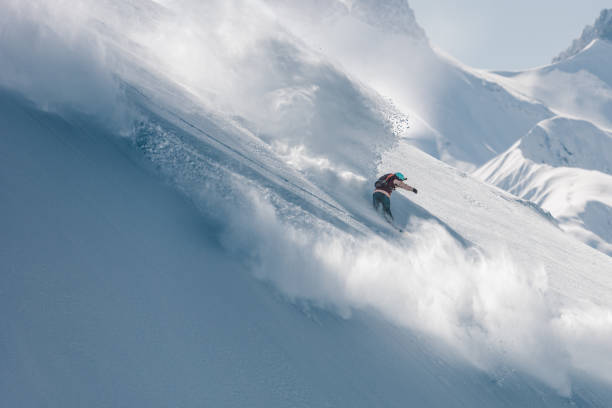 istock Extreme snowboarder snowboarding on fresh powder snow 1053568340