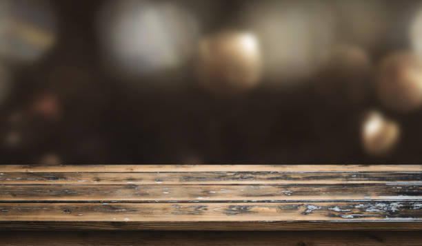 istock Dark christmas bokeh background with wooden table 1053572924