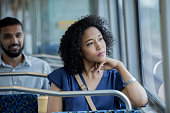istock Young businesswoman gazing out window while riding public transportation commuter train 1053580090