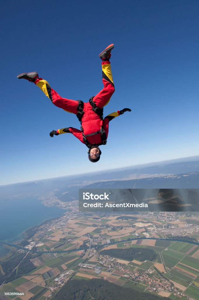 Sky diver falls towards rural area Lofty skies above and below Taking the Plunge Stock Photo