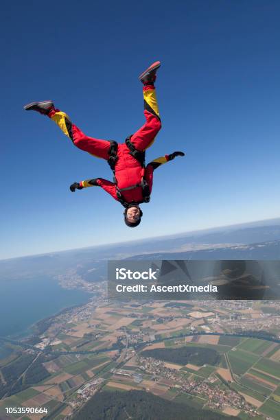 Sky Diver Falls Towards Rural Area Stock Photo - Download Image Now - Taking the Plunge, Below, People
