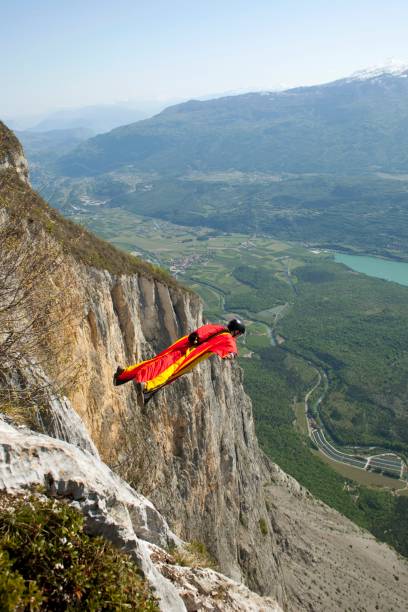 wingsuiter はスイス アルプスの崖をオフに起動します。 - skydiving parachute parachuting taking the plunge ストックフォトと画像