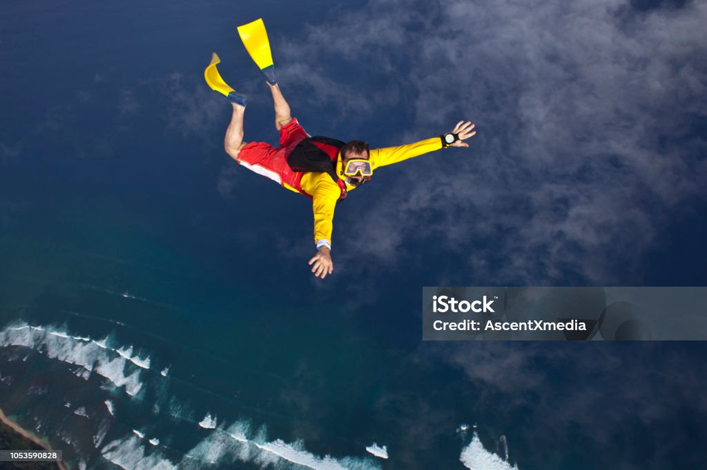 Sky diver falls with flippers and a mask Lofty skies above and below Humor Stock Photo