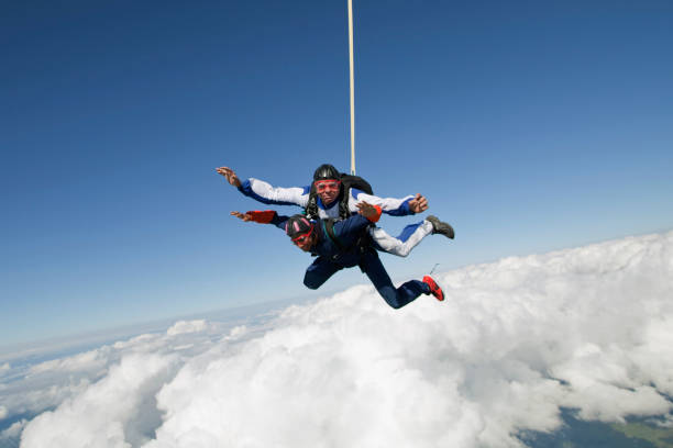mergulhadores do céu em tandem cair através das nuvens - skydiving parachute parachuting taking the plunge - fotografias e filmes do acervo