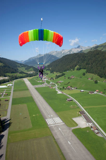 parapente desliza sobre a pista de avião alpes - skydiving parachute parachuting taking the plunge - fotografias e filmes do acervo