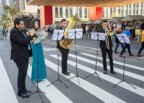 Sao Paulo, Brazil - August 27, 2017 - Group of people playing outdoor wind instruments. On Sunday Avenida Paulista is closed for cultural and leisure events for locals and tourists.