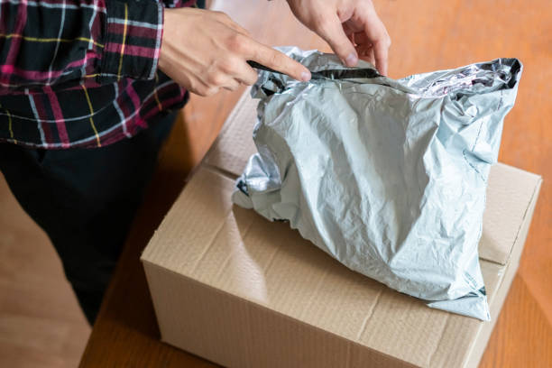istock hands using knife to open the delivered package  at home f 1053603876