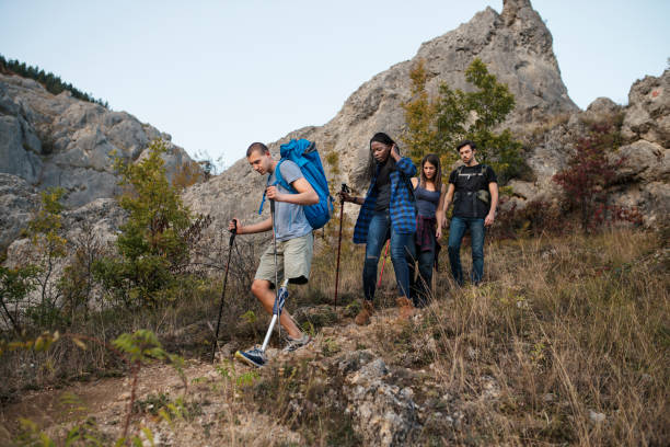 Friends hiking Close up of a group of friends hiking together. Among them is a disability young man with a prosthetic leg disabled person hiking outdoors stock pictures, royalty-free photos & images