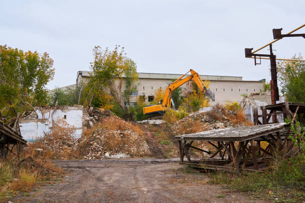 istock Yellow excavator breaks an old brick building. 1053608790
