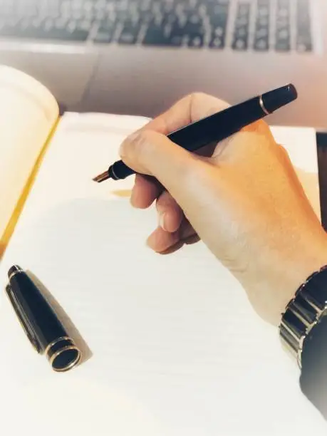 Hand writing with a stylish gold plated fountain pen
