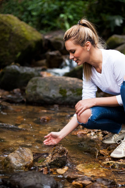 istock Woman takes water from a stream 1053623302