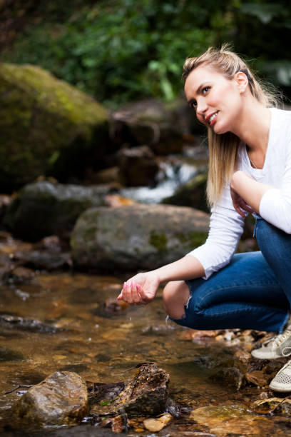 istock Woman takes water from a stream 1053623916