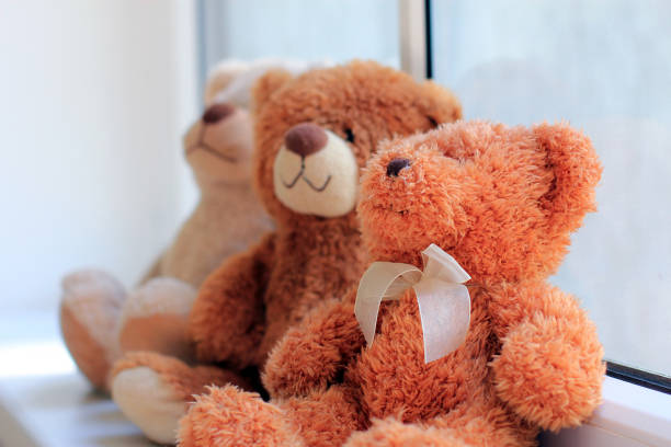 istock Three bears toys sitting on window sill. Focus on foreground toy. 1053627166