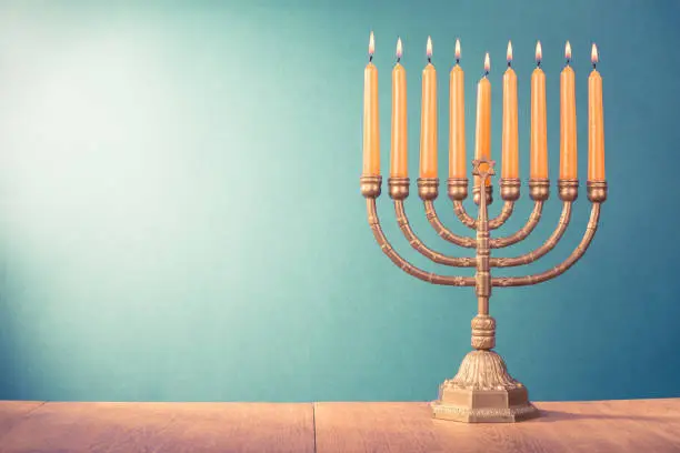 Hanukkah menorah with burning candles for holiday card background. Retro old style filtered photo