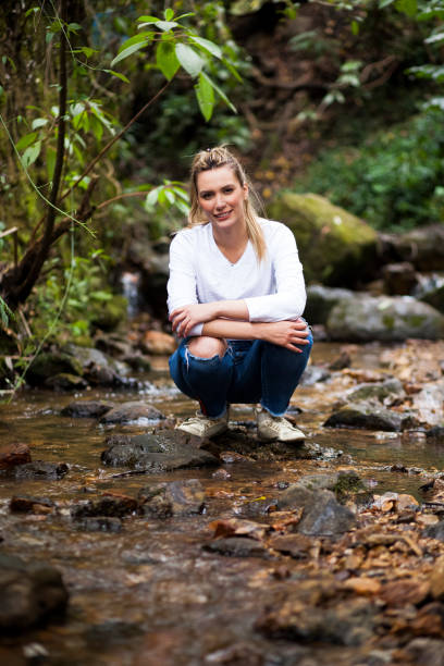istock Woman takes water from a stream 1053633602