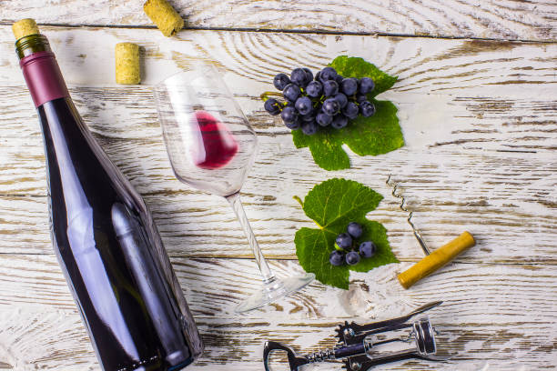 istock Bottle of wine, grapes and corks on wooden background 1053647678