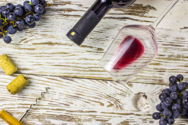 istock Bottle of wine, grapes and corks on wooden background 1053647680