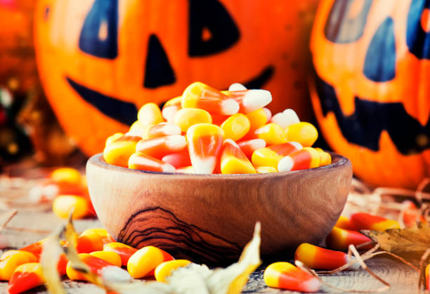 istock Halloween festive composition with sweet corn in bowl and smiling pumpkins guards 1053647954