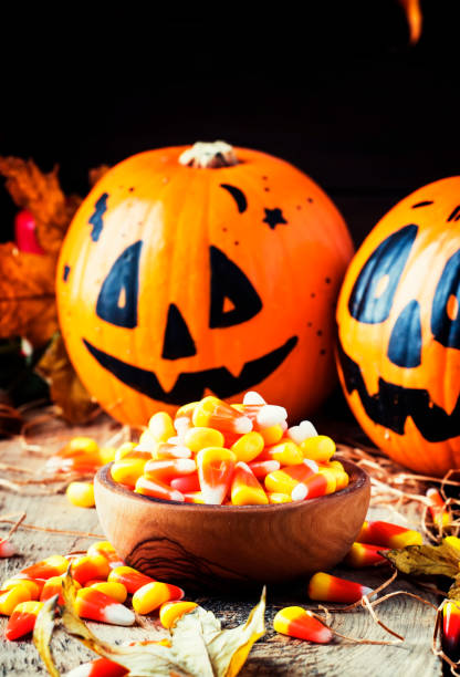 istock Halloween festive composition with sweet corn in bowl and smiling pumpkins guards 1053647984