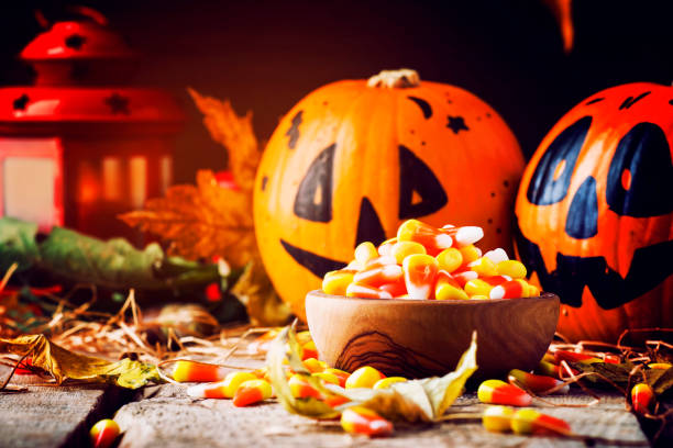 istock Halloween festive composition with sweet corn in bowl and smiling pumpkins guards 1053647986