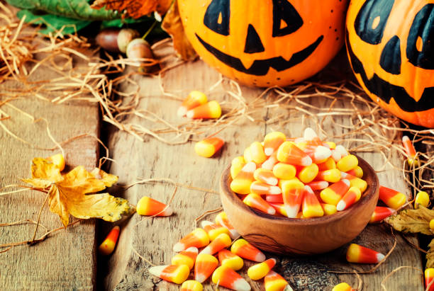 istock Halloween festive composition with sweet corn in bowl and smiling pumpkins guards 1053648016