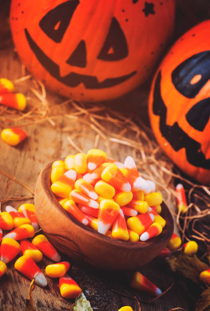 istock Halloween festive composition with sweet corn in bowl and smiling pumpkins guards 1053648024